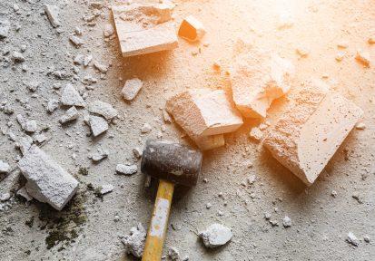 Business trouble and fear overcome concept. hammer smash with light brick mass break apart construction.