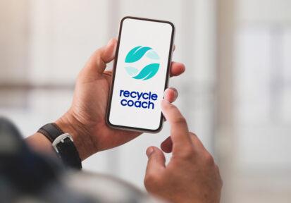 Close up view of a man using the recycle coach app on his cell phone