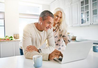 Couple looking at computer in their kitchen