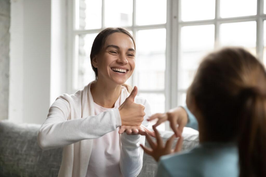 Young woman and girl communicating using sign language.
