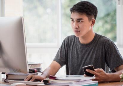 Student learning online study concept: Asian Young man sitting h