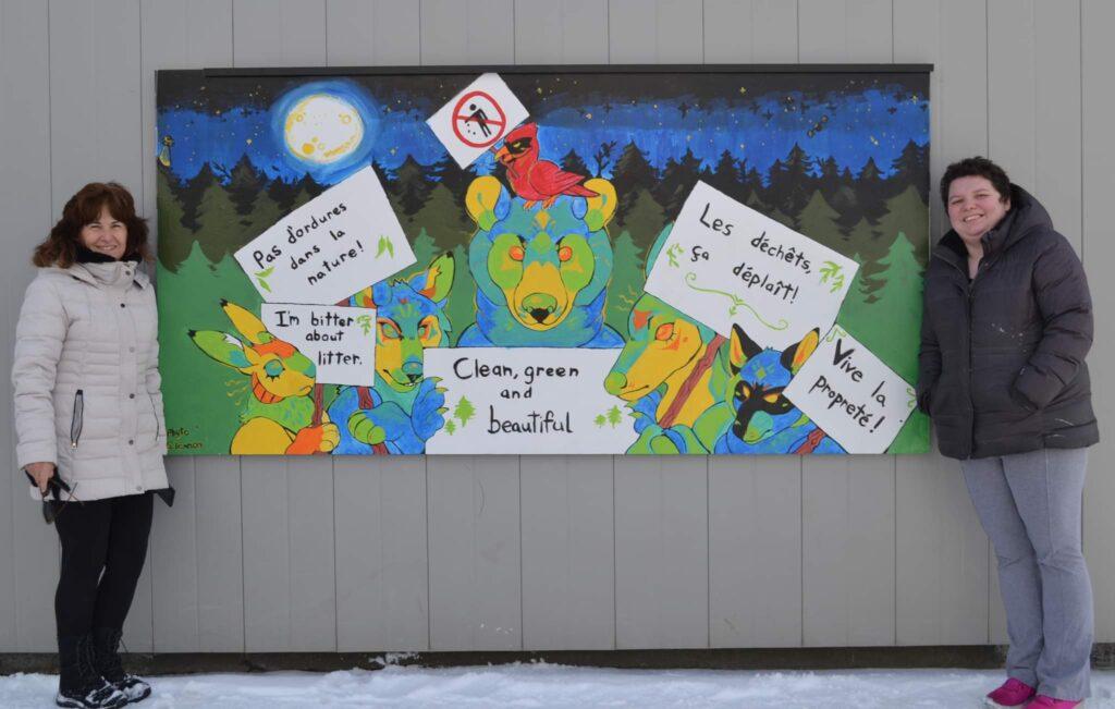 Photo of a painted mural featuring local animal life carrying bilingual signs protesting the harmful effects of litter.